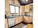 Bright kitchen with stainless steel dishwasher, light wooden cabinets, and black countertop at 1813 Birch Dr, Plainfield, IN 46168