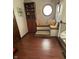 Cozy sitting area with custom built-in seating, bookshelf, round window, and dark wood floors at 1813 Birch Dr, Plainfield, IN 46168