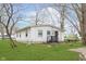 Cozy single-story home featuring white siding, a compact backyard, and mature trees at 1946 N Riley Ave, Indianapolis, IN 46218