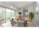 Light-filled dining room with a wooden table, minimalist chairs, and a large window offering views of the backyard at 1946 N Riley Ave, Indianapolis, IN 46218