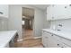 Galley-style kitchen with white cabinets, modern hardware, stainless steel appliances, and hardwood flooring throughout at 1946 N Riley Ave, Indianapolis, IN 46218