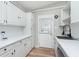 Well-lit kitchen with white cabinets, tile backsplash, a stainless steel dishwasher, and wood-look flooring at 1946 N Riley Ave, Indianapolis, IN 46218