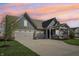Charming single-Gathering home featuring a three-car garage, covered porch and well-manicured lawn at dusk at 1972 Mobley Dr, Westfield, IN 46074