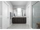 Bright bathroom featuring double vanities, neutral countertops, large mirrors, and a glass door shower at 2043 Winthrop Ave, Indianapolis, IN 46202