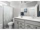 Well-lit bathroom featuring double sinks, a large mirror, a patterned shower curtain, and a toilet at 2043 Winthrop Ave, Indianapolis, IN 46202
