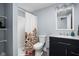 A cozy bathroom featuring a single vanity, a toilet, a shower with a curtain, and a stylish mirror at 2043 Winthrop Ave, Indianapolis, IN 46202