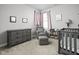 This peaceful Bedroom features a glider and ottoman, a crib, and a dresser with soft, neutral tones at 2043 Winthrop Ave, Indianapolis, IN 46202