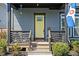 Inviting front porch with seating and a pop of color from the yellow door sets a welcoming tone at 2043 Winthrop Ave, Indianapolis, IN 46202