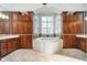 Luxurious bathroom with a large soaking tub, cherry cabinets, and a bright window at 219 Surrey Hill, Noblesville, IN 46062