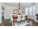 Formal dining room featuring a rustic table, elegant seating, modern light fixture, and natural light from the bay window at 219 Surrey Hill, Noblesville, IN 46062