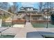Waterfront home featuring a large wood deck, seawall, steps, and a small dock with a boat lift at 219 Surrey Hill, Noblesville, IN 46062