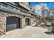Stone pillar accented two car garage with black doors and paved parking area at 219 Surrey Hill, Noblesville, IN 46062