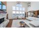 Bright living room with soaring ceilings, large windows with lake views, a stone fireplace, and comfortable white seating at 219 Surrey Hill, Noblesville, IN 46062