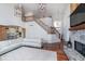 Bright and open living room featuring a fireplace, staircase, access to the kitchen, and large windows for natural light at 219 Surrey Hill, Noblesville, IN 46062