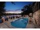 Gorgeous in-ground pool with patio seating overlooking a waterfront property at dusk at 219 Surrey Hill, Noblesville, IN 46062