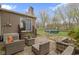 A back patio with a seating area, stone wall, stairs to the back door, and backyard at 2210 Douglas Rd, Indianapolis, IN 46220