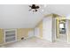 Bedroom with sloped ceilings, fan, built-in shelves, drawers, and an adjacent door at 2210 Douglas Rd, Indianapolis, IN 46220