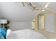 Bedroom with sloped ceilings, fan, built-in drawers, and adjacent bathroom door at 2210 Douglas Rd, Indianapolis, IN 46220