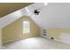 Bright bedroom with sloped ceilings, fan, window, built-in shelves, and drawers at 2210 Douglas Rd, Indianapolis, IN 46220