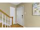 Bright entryway featuring neutral walls, white door, and wooden banister at 2210 Douglas Rd, Indianapolis, IN 46220
