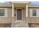 Inviting front porch with stone accents and a stylish entrance door and detailed accents at 2210 Douglas Rd, Indianapolis, IN 46220