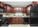 Functional kitchen with cherry cabinets, neutral countertops, and essential appliances at 2210 Douglas Rd, Indianapolis, IN 46220