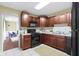 Cozy kitchen featuring cherry cabinets and modern black appliances and neutral countertops at 2210 Douglas Rd, Indianapolis, IN 46220