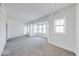 Bright living room features neutral carpet, fresh paint, and multiple windows at 230 E 9Th St # 502, Indianapolis, IN 46204