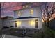 Charming two-story home featuring a covered front porch with white accents and black doors at dusk at 241 N Tacoma Ave, Indianapolis, IN 46201