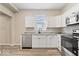 Bright kitchen featuring white cabinets, stainless steel appliances, and gray-tone vinyl floors at 241 N Tacoma Ave, Indianapolis, IN 46201