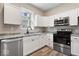 Well-lit kitchen featuring white cabinets, stainless steel appliances, and a modern countertop at 241 N Tacoma Ave, Indianapolis, IN 46201