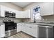 Modern kitchen featuring stainless steel appliances, granite countertops, and sleek white cabinets at 243 N Tacoma Ave, Indianapolis, IN 46201
