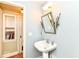 Charming bathroom featuring a pedestal sink, silver-framed mirror, and fresh lavender accents at 25 W 59Th St, Indianapolis, IN 46208