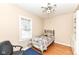 Comfortable bedroom features a twin bed, wood floors and neutral walls at 25 W 59Th St, Indianapolis, IN 46208