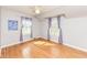 Well-lit bedroom with wood floors, two windows, and violet curtains at 25 W 59Th St, Indianapolis, IN 46208