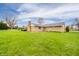 Exterior rear view showcases a well-kept lawn and the back of a classic brick home at 2511 Ritter Dr, Anderson, IN 46012