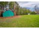 Lush backyard featuring a vibrant shed surrounded by mature trees, ideal for outdoor storage and activities at 2511 Ritter Dr, Anderson, IN 46012