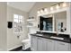 Bright bathroom featuring double sinks, modern fixtures, black countertops and flooring, and floating shelves at 253 1St Nw St, Carmel, IN 46032