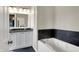 Bathroom featuring double sinks with modern fixtures, black countertops, and a bathtub at 253 1St Nw St, Carmel, IN 46032