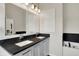 Bathroom featuring double sinks with modern fixtures and black countertops at 253 1St Nw St, Carmel, IN 46032