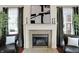 Classic fireplace with a marble surround, flanked by chairs and windows with elegant curtains at 253 1St Nw St, Carmel, IN 46032