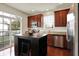 Modern kitchen with stainless steel appliances, a dark island, and a view to the backyard at 253 1St Nw St, Carmel, IN 46032