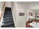 Carpeted staircase leading into a living room with hardwood floors and matching furniture at 253 1St Nw St, Carmel, IN 46032
