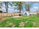 This backyard is fenced and features mature trees and a seating area with a grill at 2737 Napoleon St, Indianapolis, IN 46203