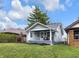 Charming home featuring a welcoming front porch with seating and well-maintained landscaping at 2737 Napoleon St, Indianapolis, IN 46203