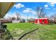Spacious backyard featuring a red shed, green lawn, and play area, perfect for outdoor activities at 318 Winfield St, Greenfield, IN 46140