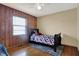 Bedroom with wood paneling, wood floors, a bright window and a ceiling fan at 318 Winfield St, Greenfield, IN 46140