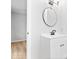 Modern bathroom with a round mirror, updated lighting, and a vanity with white cabinets at 322 S Boehning St, Indianapolis, IN 46219