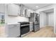 Modern kitchen featuring stainless steel appliances, sleek white cabinets, and a stylish range hood at 322 S Boehning St, Indianapolis, IN 46219