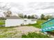 Backyard featuring multiple storage sheds, a well manicured lawn and a bright blue deck and stair area at 359 N Whitcomb Ave, Indianapolis, IN 46224